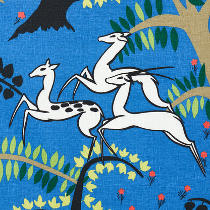 Blue fabric pattern with white stylized cranes on branches, green leaves and tiny red flowers.