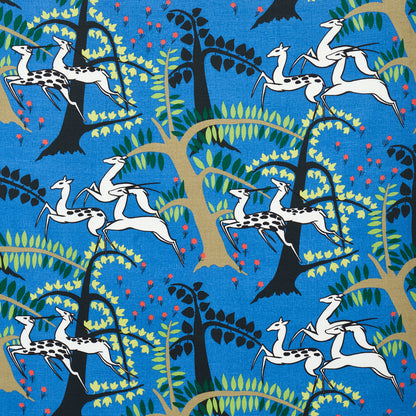Bright blue fabric print with white llama silhouettes among whimsical green and yellow trees and pink blossoms.