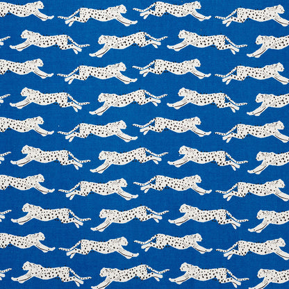 Blue fabric with repeating white leopard silhouettes in a running pattern; playful safari print for apparel or decor.