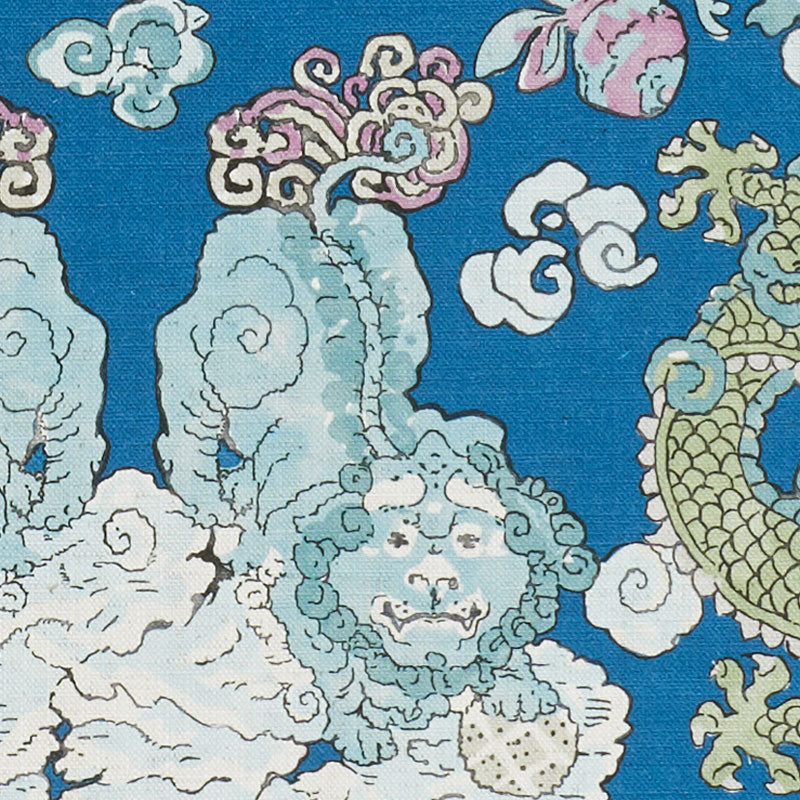 Blue textile with pale teal cloud motifs, curling white clouds, and a gold dragon accent in an oriental print.