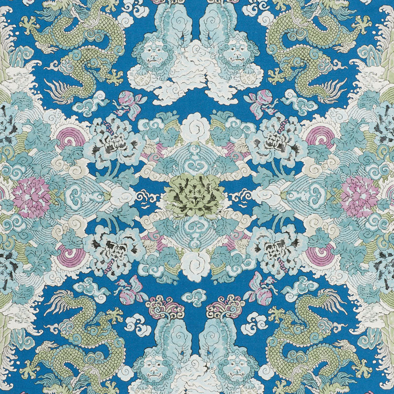 Blue decorative fabric with mirrored Chinese dragon and cloud motif in teal, white, pink and gold accents.