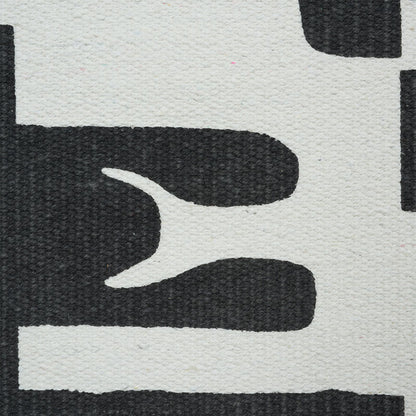 Close-up of a textured cream rug with bold black abstract curved shapes for a modern geometric look.