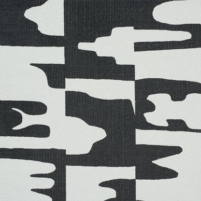 Abstract black and white canvas textile with irregular white shapes on a dark background, a modern geometric pattern.