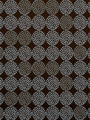 Brown upholstery fabric with repeating pale gray dotted circular motifs in a floral pattern.