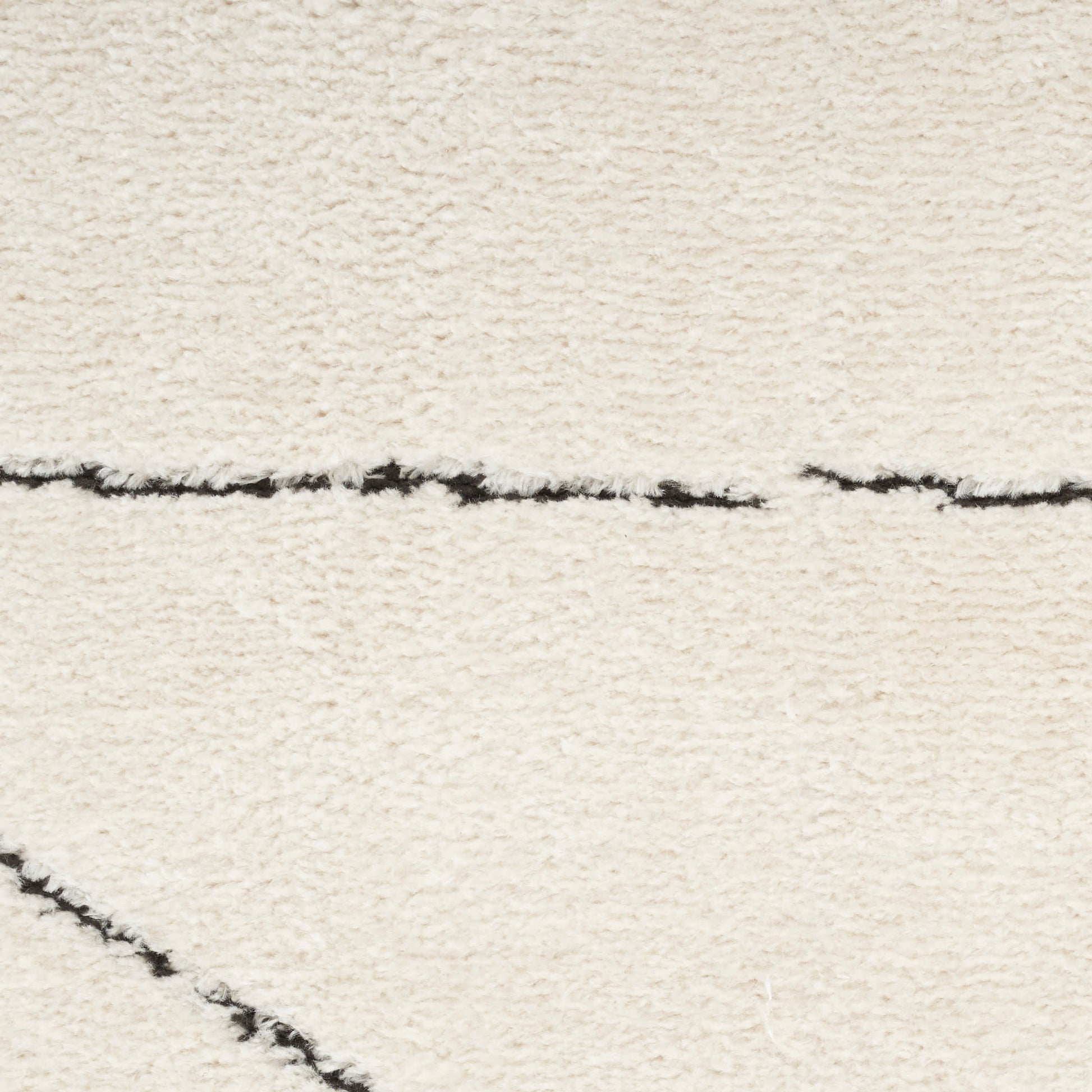 Cream shag rug with subtle black linear pattern and plush pile.