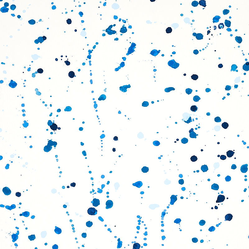 Abstract blue watercolor splatters on white background; random ink dots and streaks in light to dark blues.