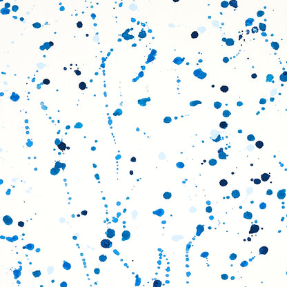 Abstract blue watercolor splatters on white background; random ink dots and streaks in light to dark blues.