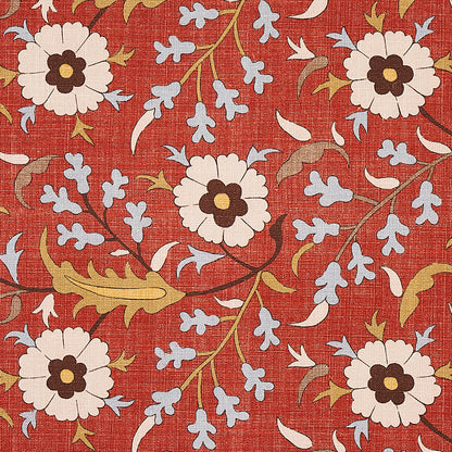 Red fabric with large white flowers, brown centers, pale blue blossoms, and olive-green vines in a botanical print.