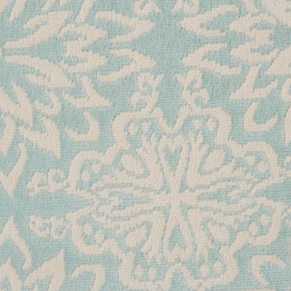 Soft blue rug with white ornamental snowflake/medallion motif; textured surface for home decor.