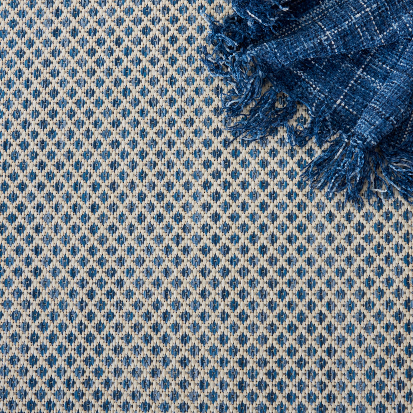 Gray gradient square framed by blue-and-white geometric patterned textile border; minimal decorative fabric.