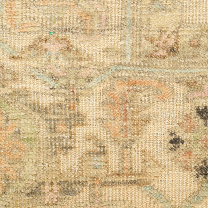 Beige vintage-style woven rug with faded floral motifs in soft apricot, blue, green and gray.