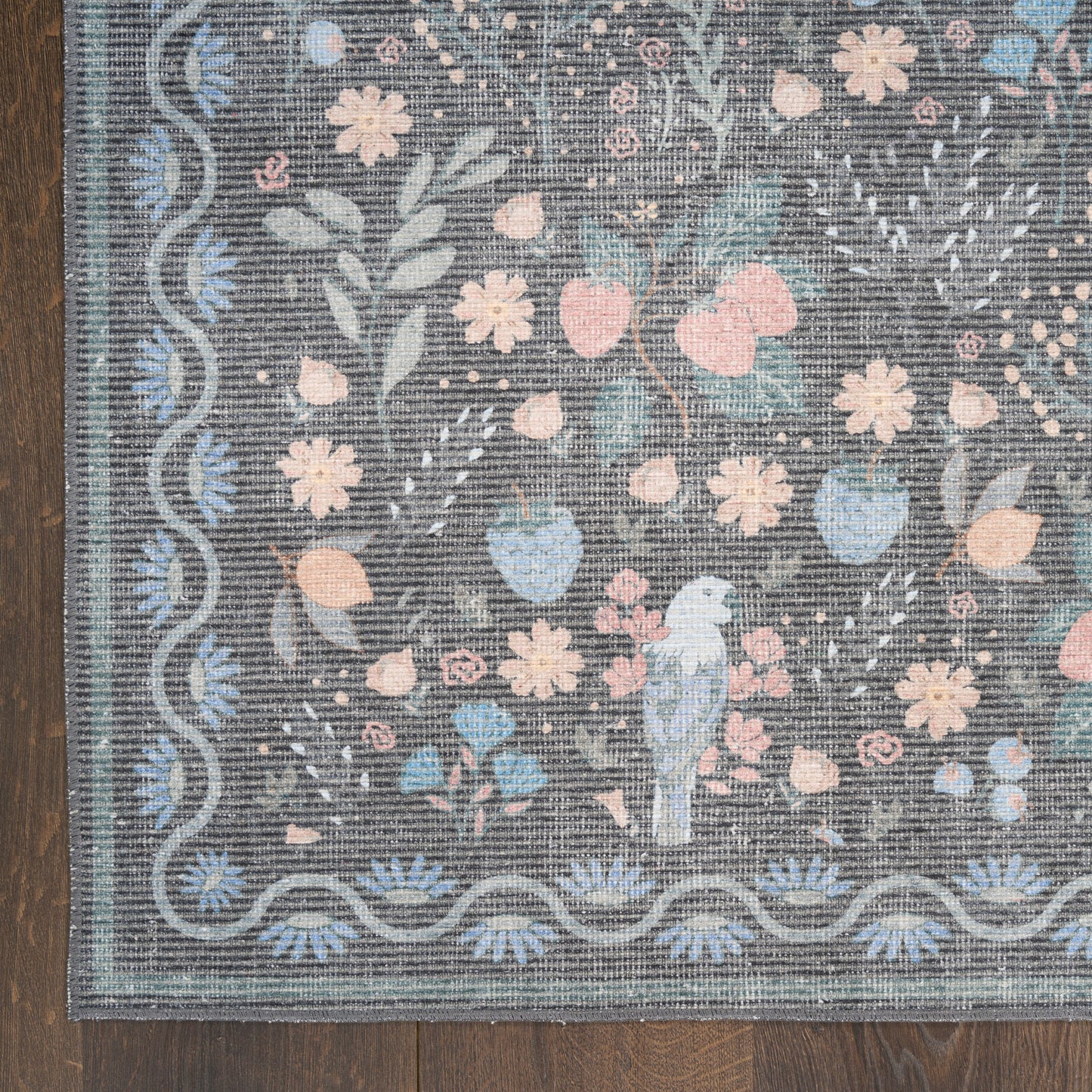 Gray-blue floral rug with pastel pink and blue blossoms, wavy border, featuring a blue parrot perched among flowers.