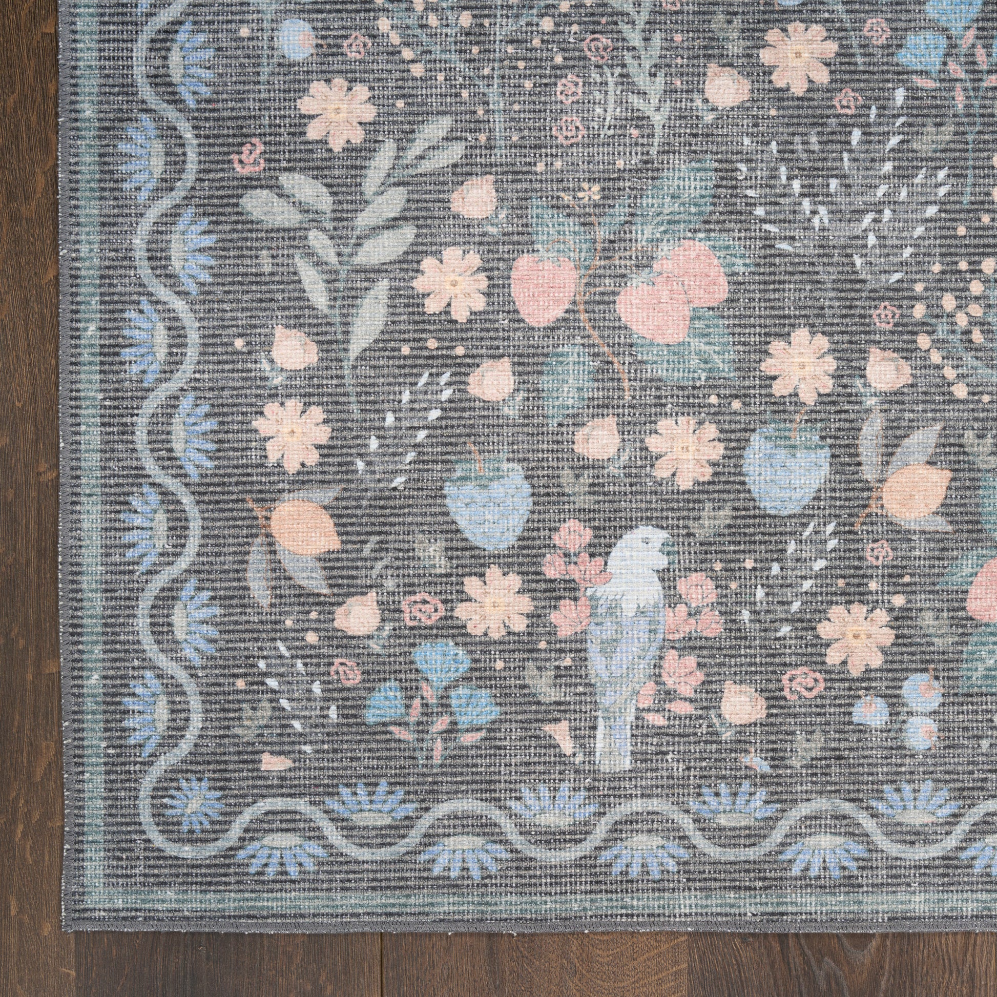 Gray-blue floral rug with pastel pink and blue blossoms, wavy border, featuring a blue parrot perched among flowers.