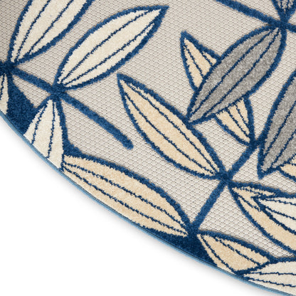 Woven rug with navy blue leaf outlines on cream background; contemporary botanical pattern.
