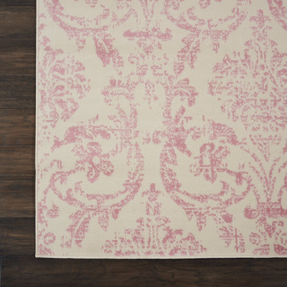 Cream rug with pink damask floral pattern on dark wood floor.