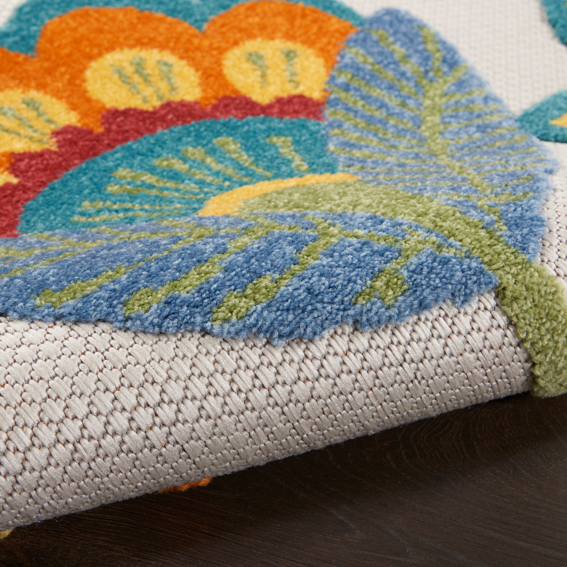 Bright butterfly-patterned rug with blue, orange and green wings on a beige woven base; soft tufted pile.