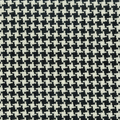 Close-up of black and white houndstooth fabric pattern; woven textile texture for apparel or upholstery.