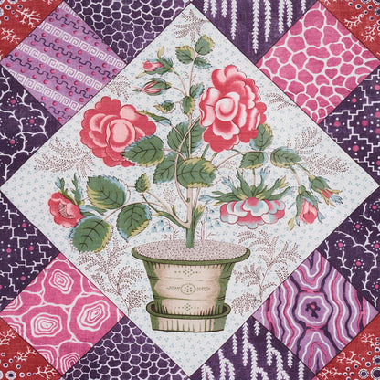Patchwork quilt panel with central potted rose and surrounding pink, purple, red diamond blocks.