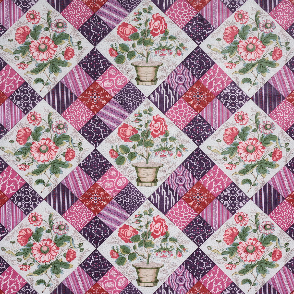 Quilted patchwork fabric with floral diamond panels showing pink roses in pots, framed by purple and magenta patterned squares.