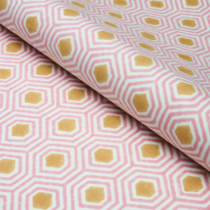 Pink and white geometric hex pattern fabric with mustard-yellow centers, rolled textile.
