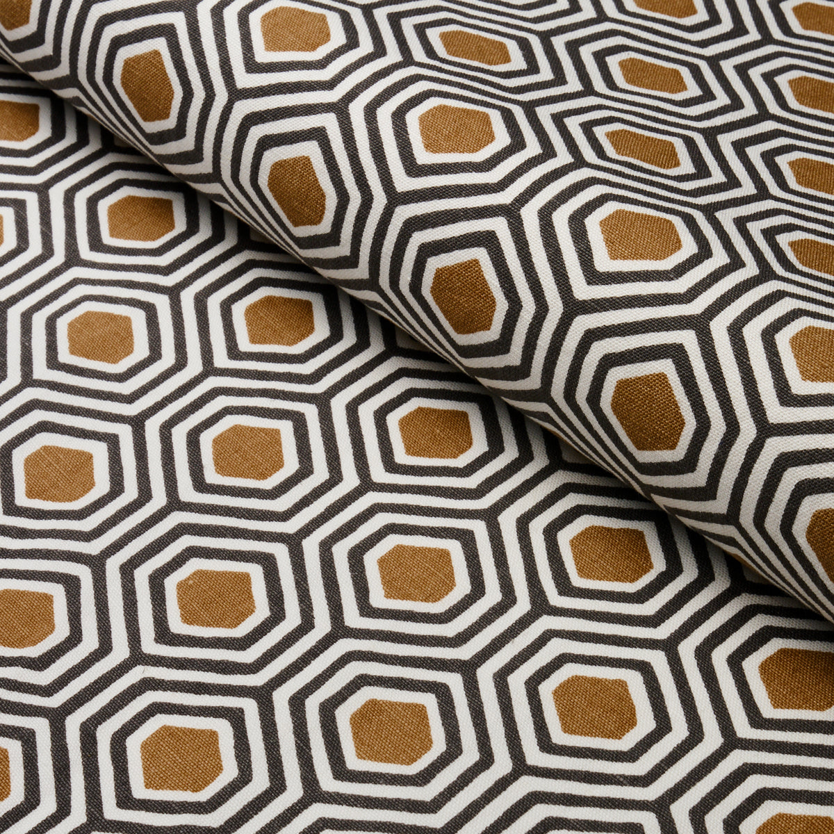 Geometric hexagon print fabric in black, white & mustard gold; hand-printed textile, folded for upholstery or decor.