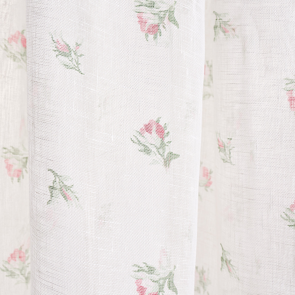 White sheer fabric with tiny pink rose prints and green leaves, light delicate curtain material.