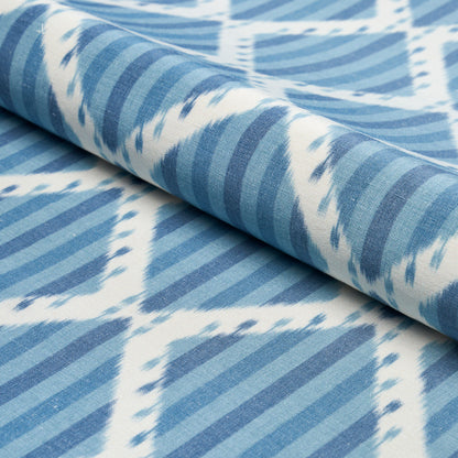 Blue and white geometric print fabric with diagonal stripes forming diamond shapes, rolled edge.