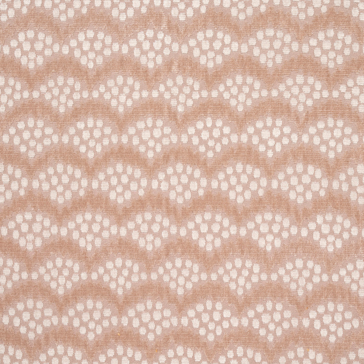 Peach lace fabric with repeating scalloped arches and dot clusters; delicate, sheer textile for dresses.