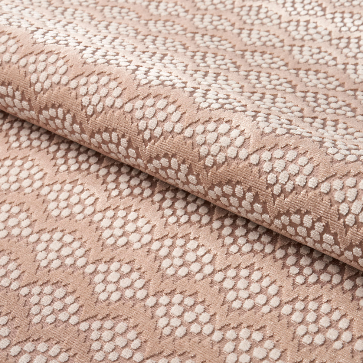 Beige woven fabric with cream dotted scallop motif, rolled textile with a soft textured finish.