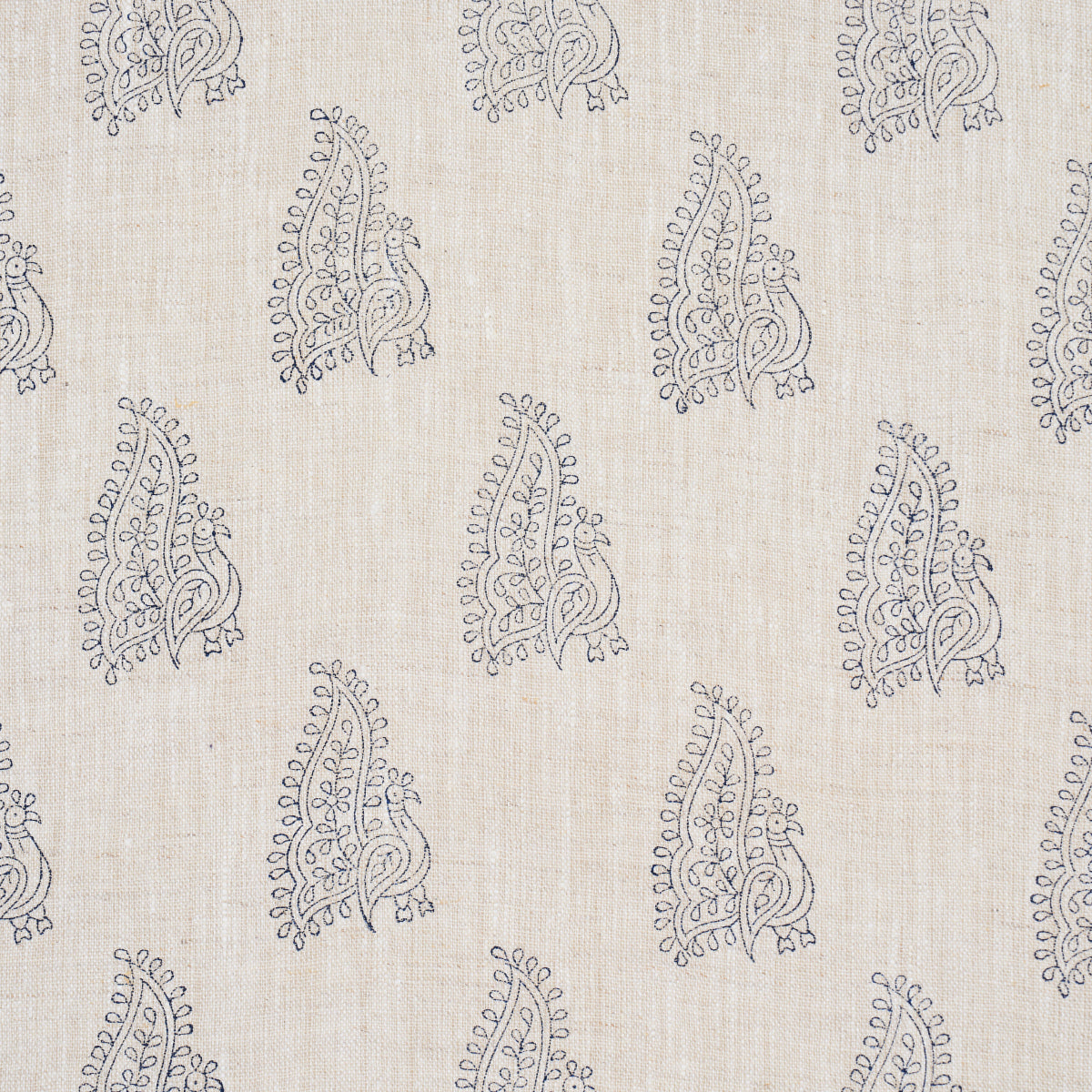 Beige flax linen fabric with repeating dark navy peacock motifs in a hand-blocked boho print.