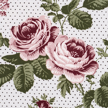 Pink roses with green leaves against a background of small black polka dots; vintage floral fabric pattern.