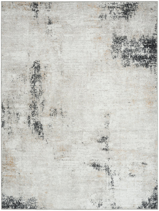 Abstract distressed cream & gray area rug with charcoal patches; rectangular, woven design.