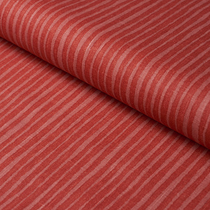 Red striped fabric with cream narrow stripes, folded; soft cotton textile for apparel or home decor.