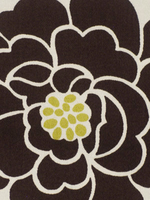Close-up of a large dark brown flower with white outline on fabric; yellow clustered center dots.