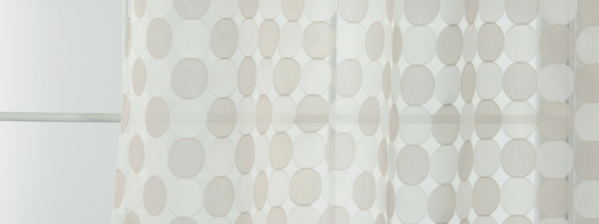 Light sheer curtain panel with large beige and gray polka dots, contemporary window treatment for airy decor.