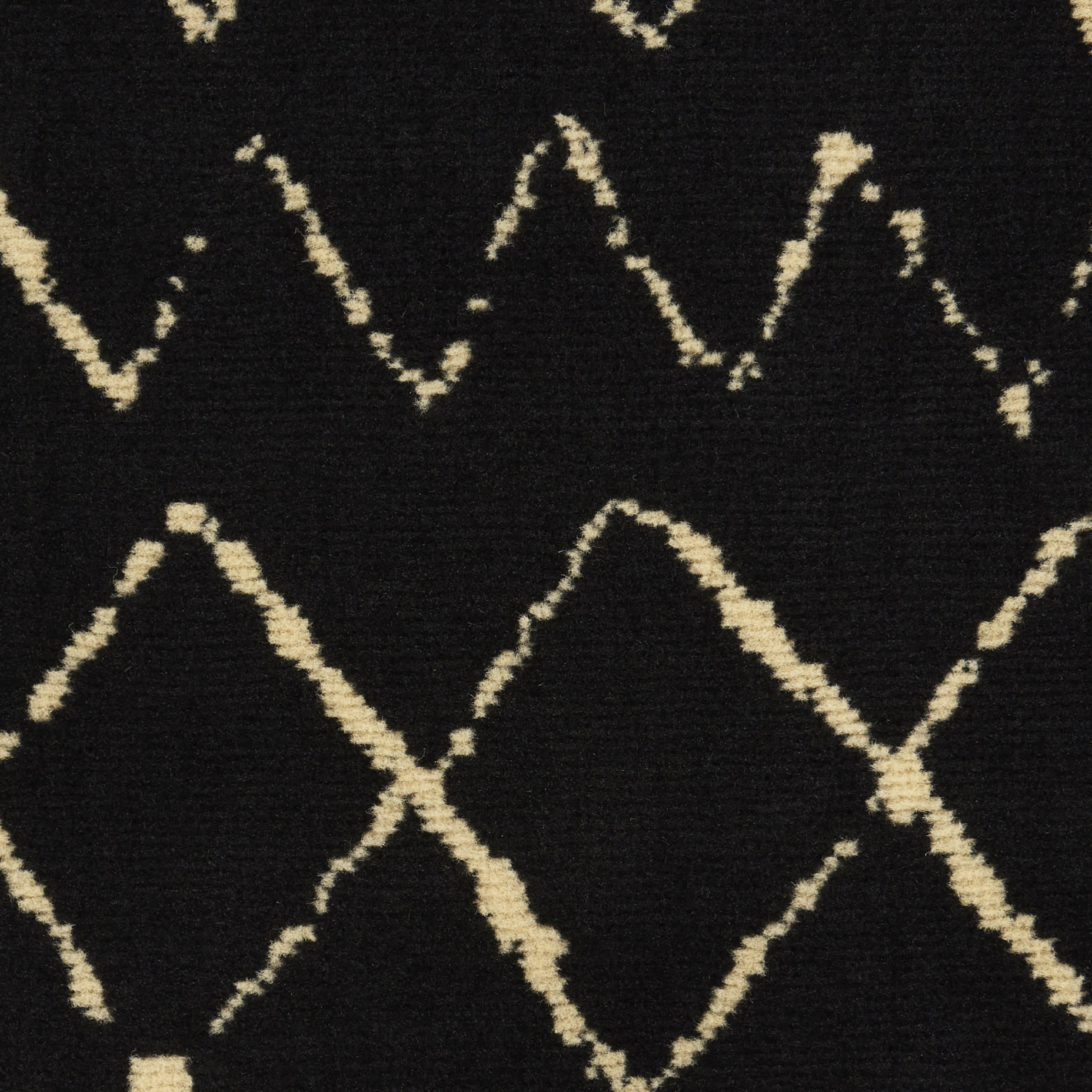 Black rug with cream diamond lattice zigzag pattern; soft woven textile for modern living spaces.