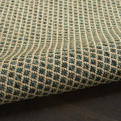 Woven runner rug in green and beige with a geometric diamond pattern and thick textured weave on a dark wood floor