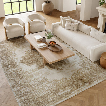Neutral living room with cream sofa, two curved-arm beige chairs, light wood coffee table, and beige patterned rug.