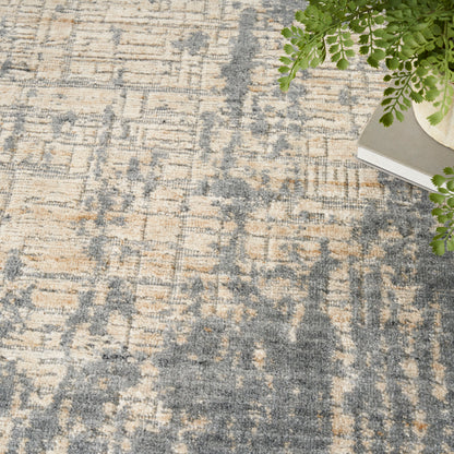 Abstract beige and blue-gray rug with distressed pattern; contemporary living room decor.
