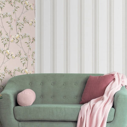 Beige wallpaper with pink floral pattern on a wall beside white paneling.