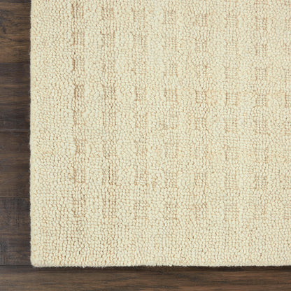 Cream boucle textured shag rug on dark wood floor.