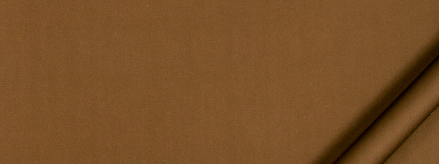 Close-up of brown kraft cardboard with two beige cylindrical tubes along the top-right corner.