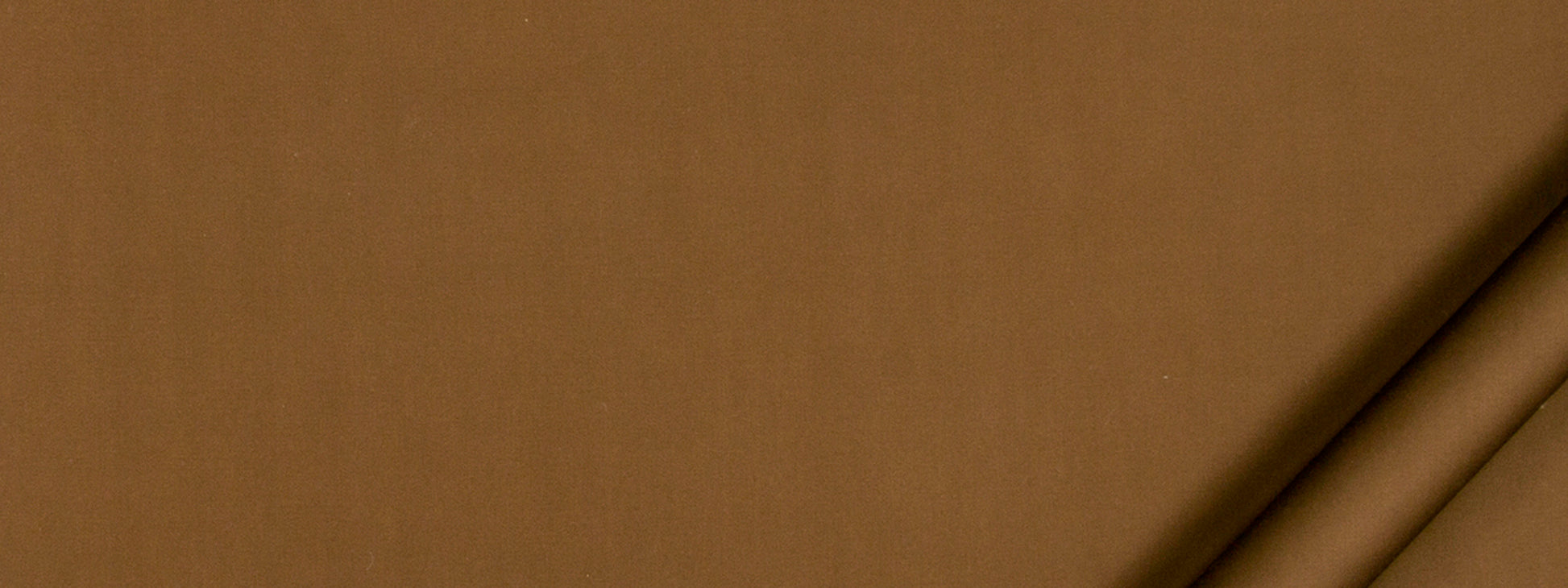 Close-up of brown kraft cardboard with two beige cylindrical tubes along the top-right corner.