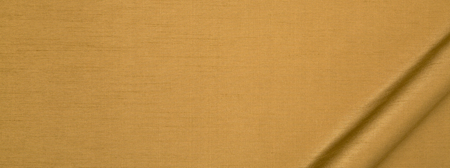 Golden mustard fabric with visible weave texture and a diagonal fold on the lower-right.