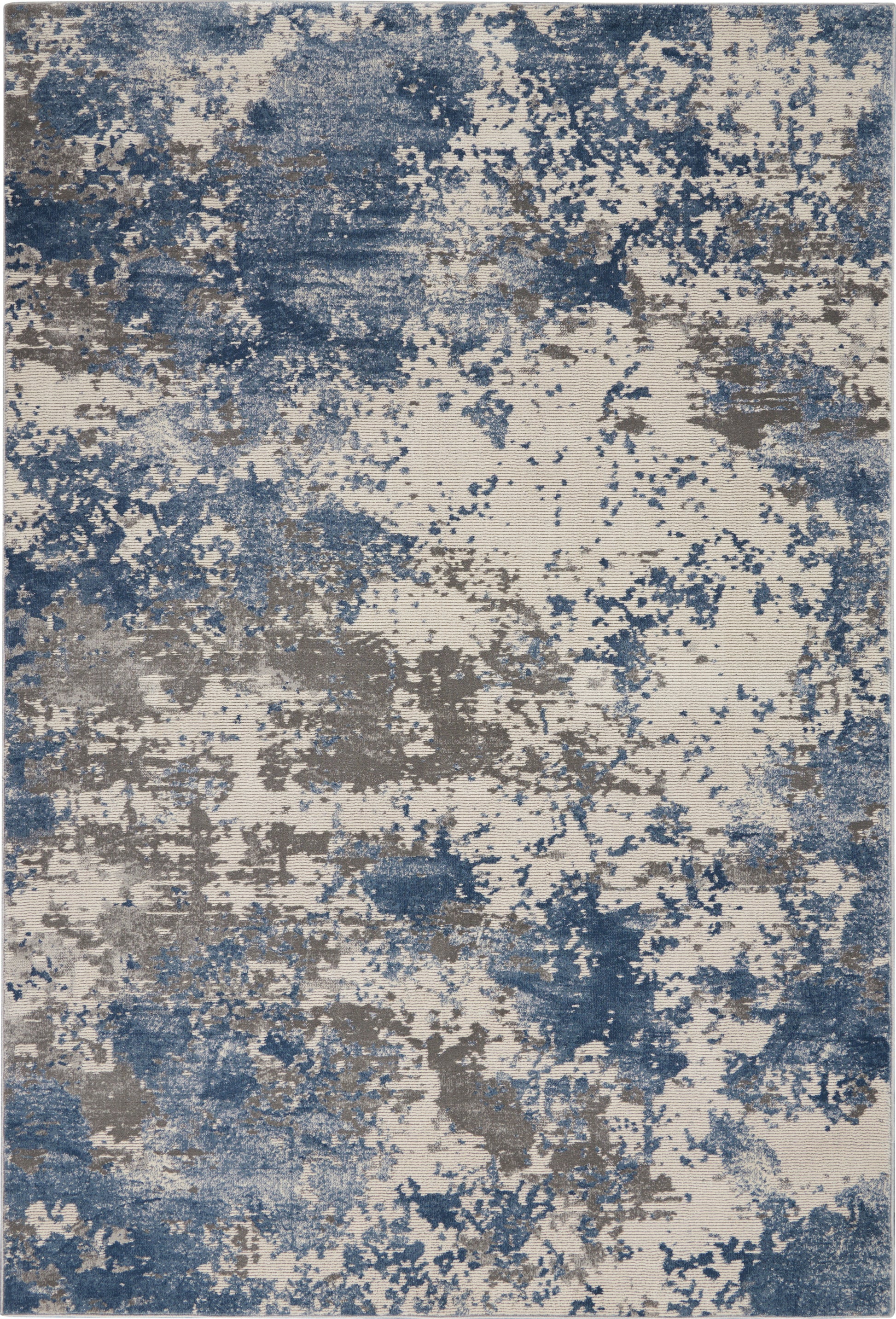Abstract blue and gray splatter rug with beige base and painterly pattern.
