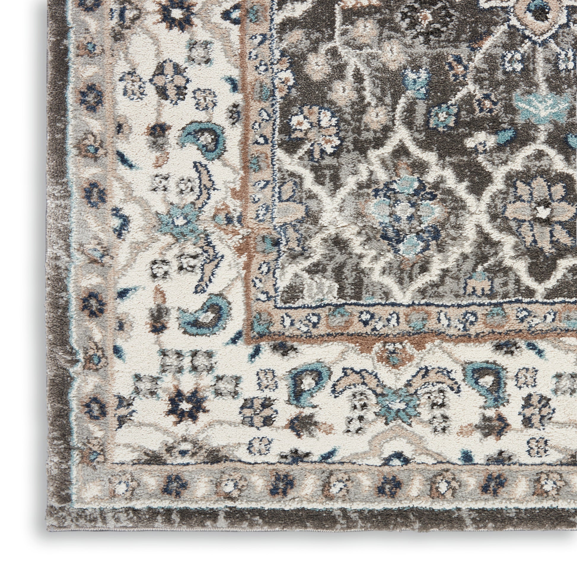 Ornate area rug close-up with ivory, brown and blue floral motifs and a decorative border.