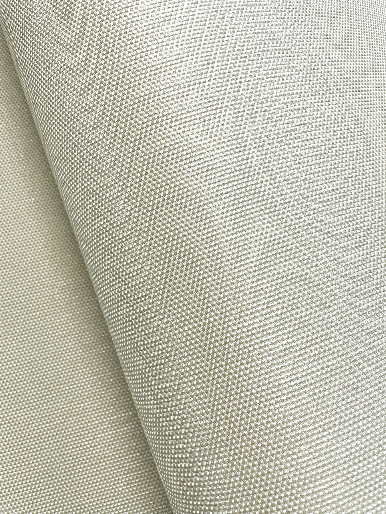 Beige wallpaper close-up with a tight, uniform grid-like weave.