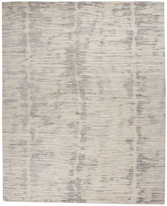 Rectangular area rug in light beige with subtle gray abstract vertical stripe pattern; soft woven texture.