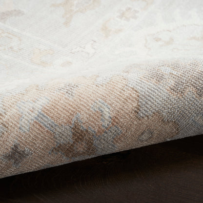 Beige and cream oriental-style rug with pale blue accents, woven texture and folded edge.