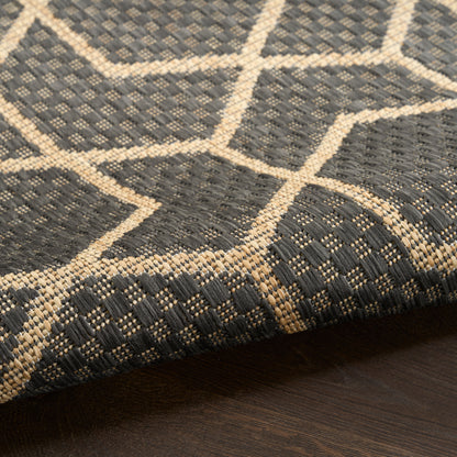 Dark gray flatweave rug with beige geometric lattice pattern and border, modern living room decor.